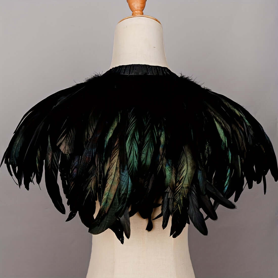 Black feathered garment on a mannequin against a gray background