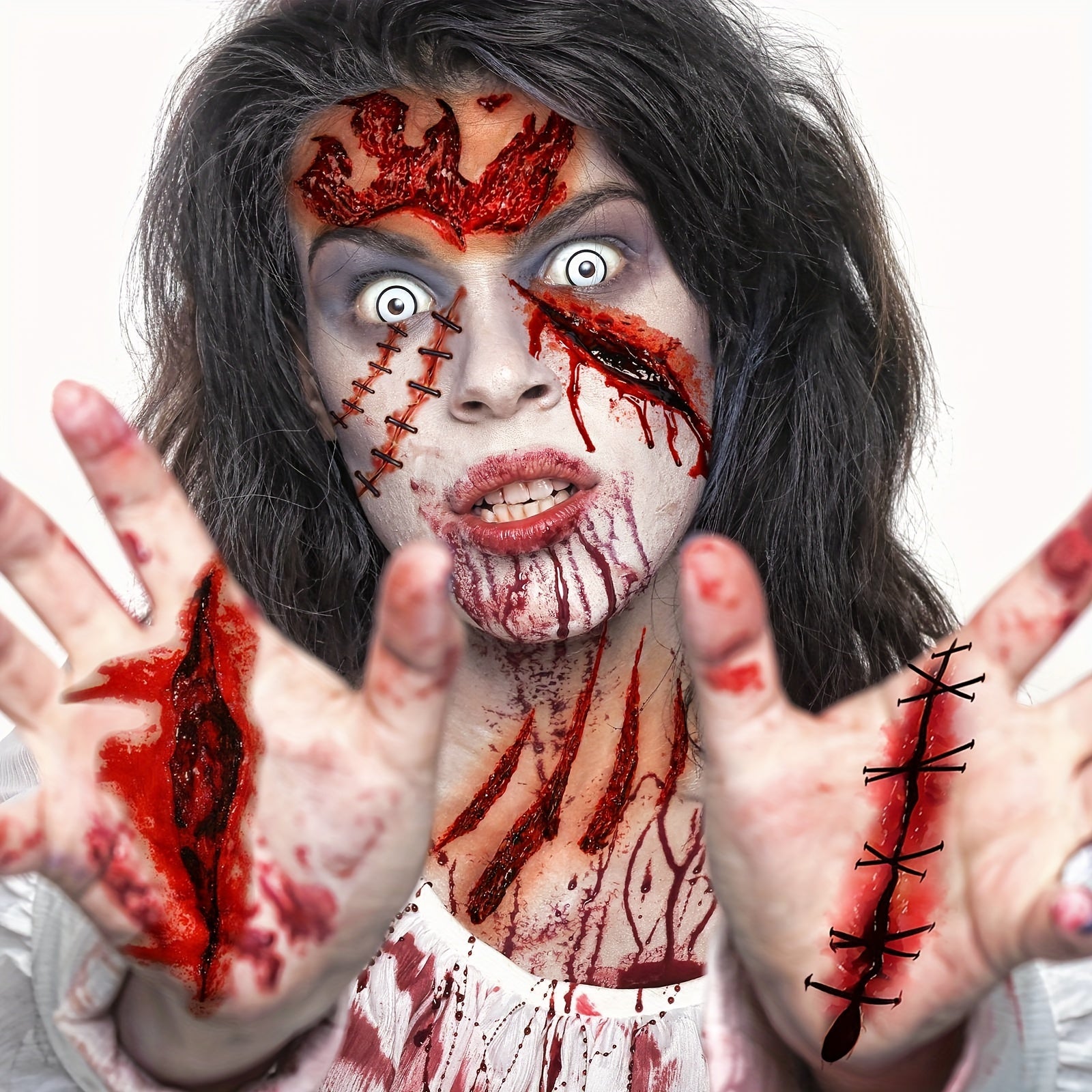 Person with zombie makeup and costume, including blood and stitches, against a white background.