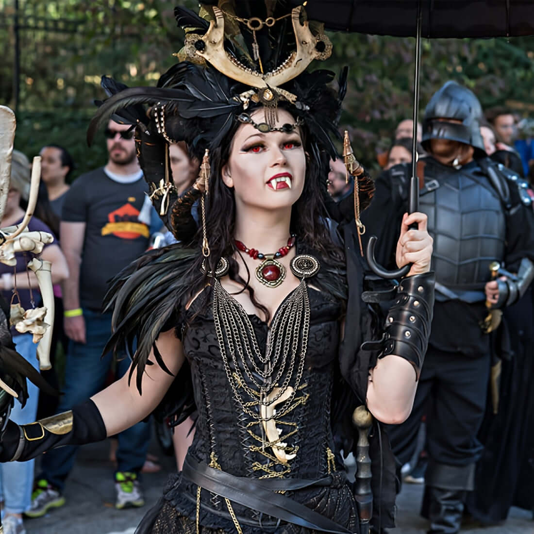 Person in elaborate dark costume with gold accents at a themed event.